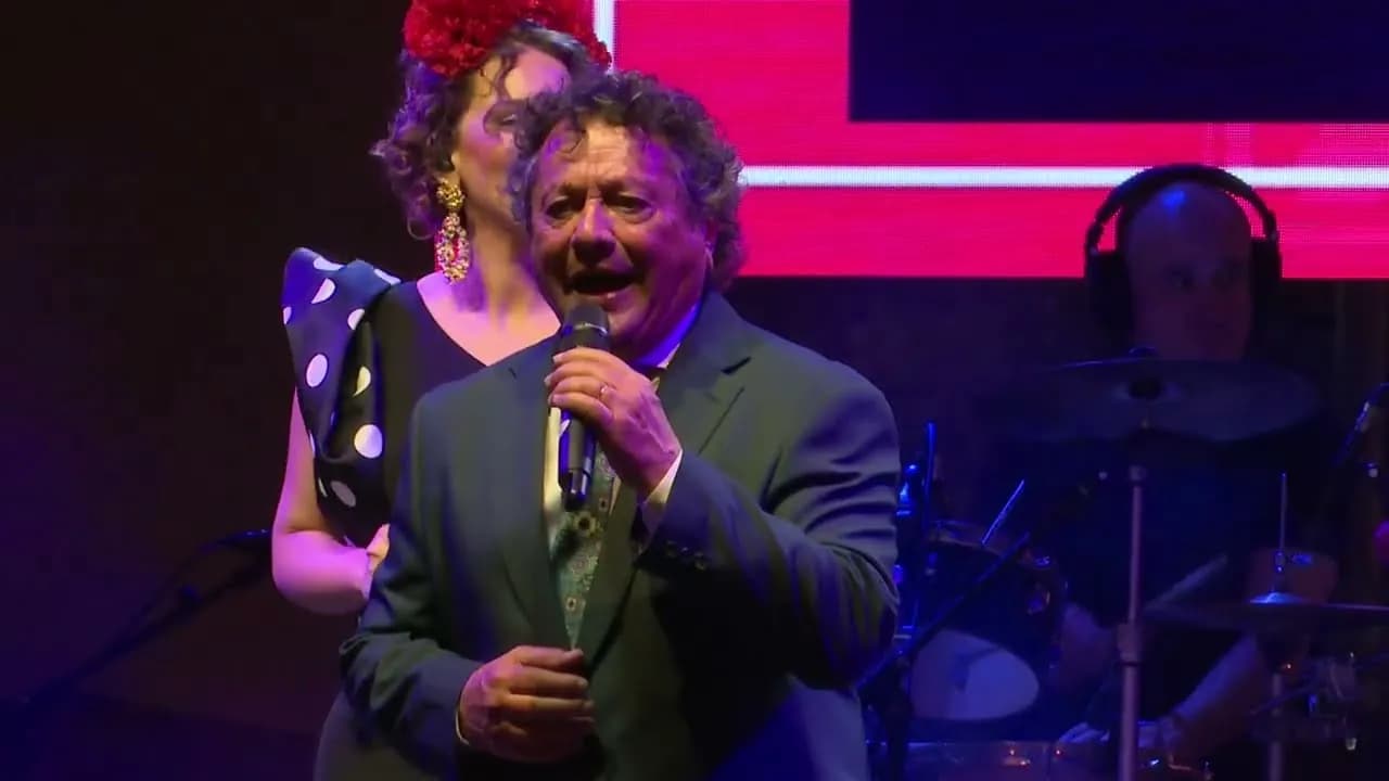 Un cantante de Raya Real en pleno directo, con la percusión detrás (Alumbrado de la Feria de Abril de Sevilla 2026)