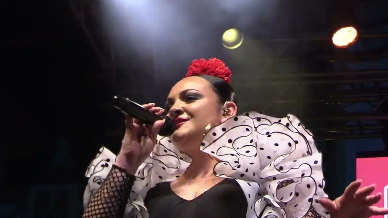 Una cantante de Raya Real con traje de lunares y flor roja (Alumbrado de la Feria de Abril de Sevilla 2026)