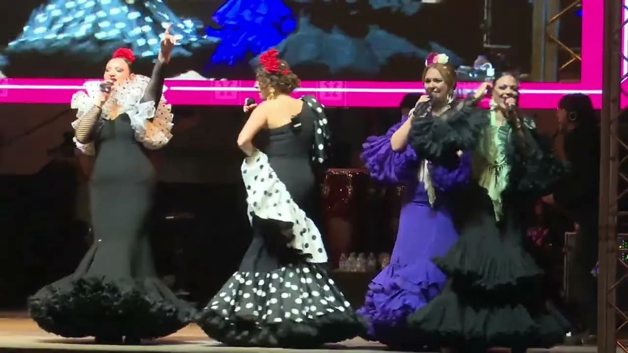 Cuatro cantantes de Raya Real bailando con traje de flamenca en el escenario (Alumbrado de la Feria de Abril de Sevilla 2026)