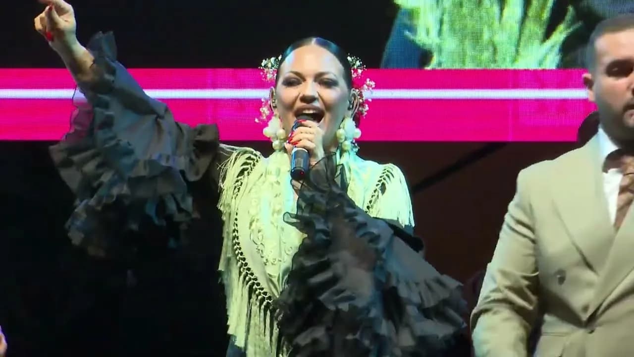 Una cantante de Raya Real con traje de flamenca verde, junto a un cantante (Alumbrado de la Feria de Abril de Sevilla 2026)