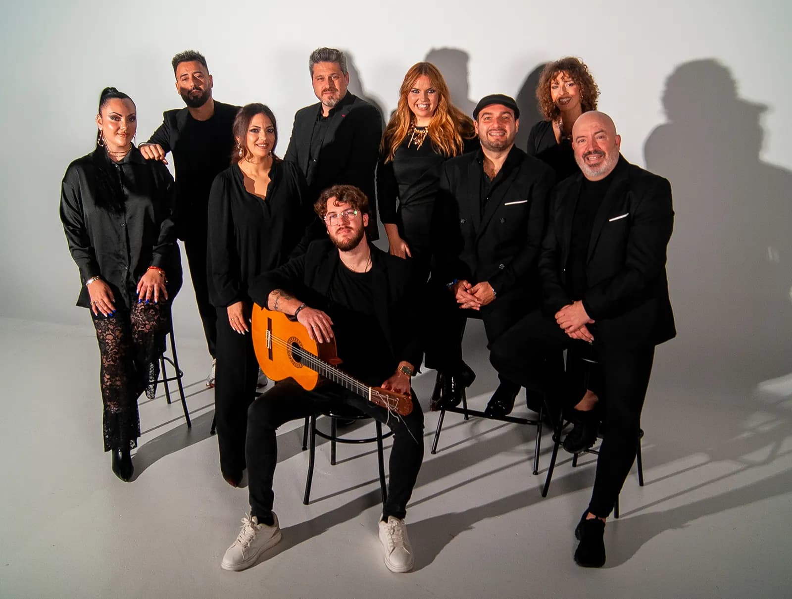 El grupo Raya Real al completo, en la sesión de fotos oficial, alrededor de la guitarra